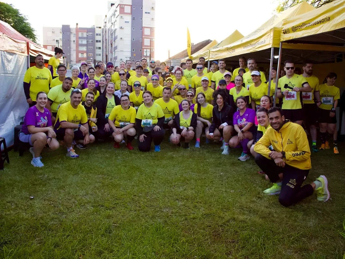 Equipe e alunos PRO Elite reunidos de camiseta amarela em uma prova